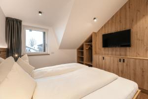 una camera con 2 letti e una TV a schermo piatto di Alpenrose Alpine Living a Selva
