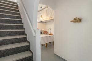 um corredor com escadas que levam a uma sala de jantar em Traditional Home em Naousa