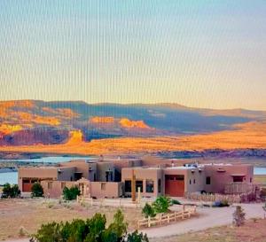 a group of buildings in the desert with mountains in the background at The Grand Hacienda Estate with Breakfast in Abiquiu