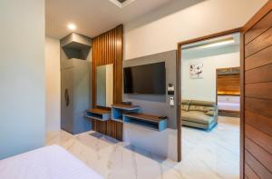 a hotel room with a bed and a television at Loy Chalet in Klong Muang Beach