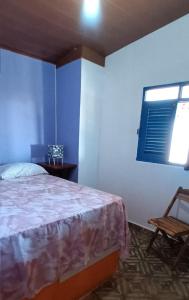 a bedroom with a bed and a window and a chair at Casinhas Vila Bonita Marajás in Baía Formosa