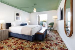 a bedroom with a large bed and a mirror at Palihouse West Hollywood in Los Angeles