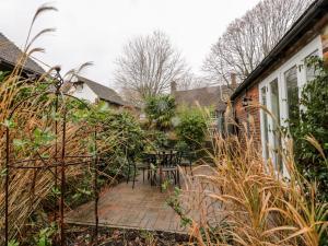 a patio with a table and chairs in a yard at 1 Little Ripple Cottages in Canterbury