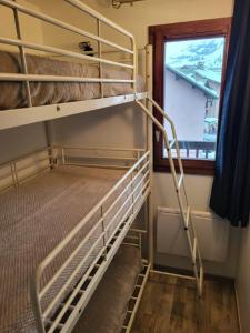 an empty bunk bed in a room with a window at APPARTEMENT VALMEINIER 1800 / RESIDENCE L'OURS BLANC in Valmeinier