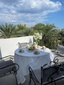 une table avec un tissu de table blanc sur une terrasse dans l'établissement Nicocreon Guest House, à Famagouste