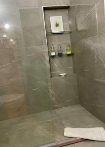 a bathroom with a shower with a glass door at Nicocreon Guest House in Famagusta