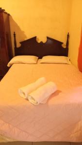 twee handdoeken zitten op een wit bed bij HOSTAL CASA BELINDA in León