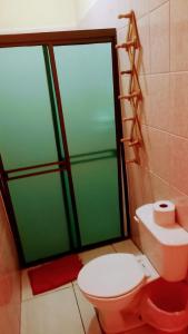 a bathroom with a toilet and a green shower door at HOSTAL CASA BELINDA in León