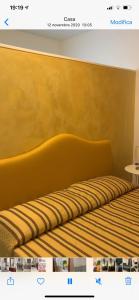 un letto con testiera gialla in una stanza di B&B San Pietro Book sharing a Nola