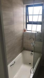 uma casa de banho com uma banheira e uma janela em St Pete Private Suites em Newton Park