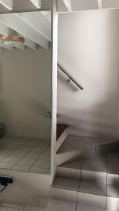um quarto com uma escada com paredes brancas e pisos em azulejo em St Pete Private Suites em Newton Park