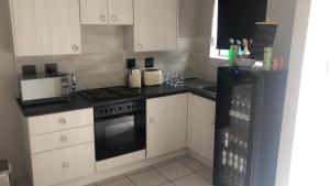a kitchen with white cabinets and a black stove top oven at Exclusive townhouse Newton Park in Newton Park