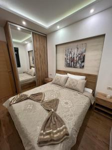 1 dormitorio con 1 cama grande y espejo grande en Vila Pekovic Blue - Apartman TORG, en Zlatibor