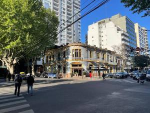 布宜諾斯艾利斯的住宿－Moderno departamento Palermo vista La Rural，人穿过街道,在旧建筑前