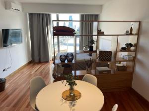 een woonkamer met een tafel en een kamer met een bed bij Moderno departamento Palermo vista La Rural in Buenos Aires