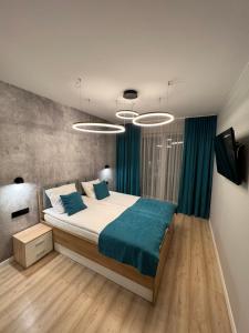 - une chambre avec un grand lit et des rideaux bleus dans l'établissement Solna Apartament PREMIUM, à Kołobrzeg
