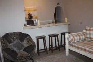 ein Wohnzimmer mit einem Sofa und einem Stuhl in der Unterkunft Little Heaven's Home, 1 bedroom cozy home in Malindi