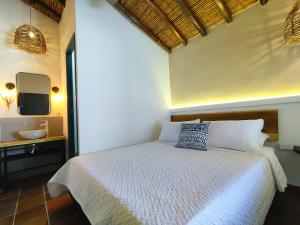 a bedroom with a white bed and a television at Trip Monkey Girón in Girón