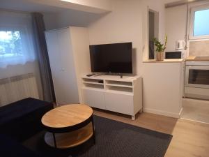 uma pequena sala de estar com televisão e mesa em Apartment Lenchy 2 em Zagreb