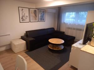 salon z czarną kanapą i stołem w obiekcie Apartment Lenchy 2 w Zagrzebiu