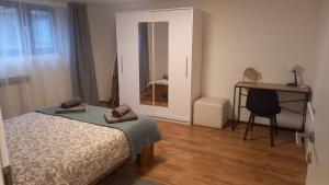 Schlafzimmer mit einem Bett, einem Schreibtisch und einem Spiegel in der Unterkunft Apartment Lenchy 2 in Zagreb