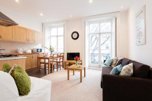 cocina y sala de estar con sofá y mesa en Dream South Kensington Apartment, en Londres