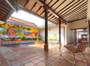 a patio with chairs and a mural on the wall at Trip Monkey Girón in Girón