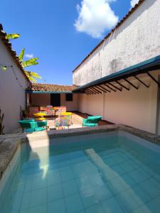einen Pool neben einem Haus mit einer Terrasse in der Unterkunft Trip Monkey Girón in Girón