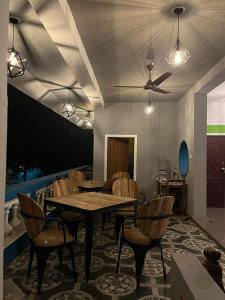 a dining room with a table and chairs and a ceiling fan at Unearth Hostel (Pondicherry) in Auroville