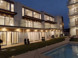 una casa grande con piscina frente a ella en Suite Nueva en Salinas - Chipipe, en conjunto privado, en Salinas