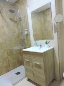 a bathroom with a shower and a sink and a mirror at Apartment with terrace and pool by the sea in Los Caños de Meca