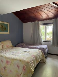 1 dormitorio con 2 camas y ventana en Casa ferradura com piscina e hidromassagem, en Búzios