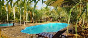 a swimming pool with two chairs and an umbrella at Vila Araticum Praia in Santo André