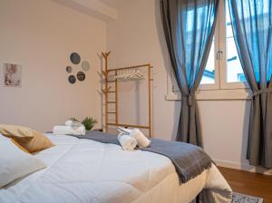 una camera da letto con un grande letto con asciugamani di Maison Blanche: appartamento elegante con parcheggio privato a Mantova