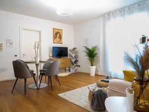 Maison Blanche: appartamento elegante con parcheggio privato في مانتوفا: غرفة معيشة مع أريكة وطاولة مع كراسي