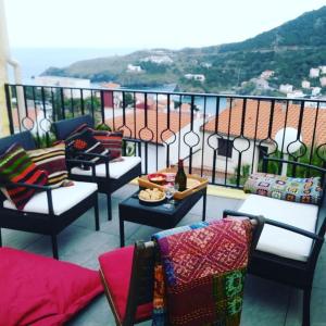 a balcony with chairs and a table with a view at Villa CapCerbere in Cerbère