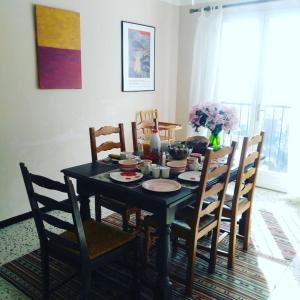 a dining room table with chairs and a black table with food on it at Villa CapCerbere in Cerbère