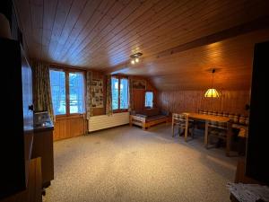 una habitación con mesa y sillas en una cabaña en Hotel Bären Lodge en Kiental