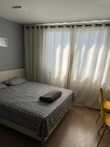 een slaapkamer met een bed met een kussen erop bij Estúdio Brás - Comercial in Sao Paulo