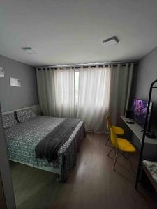 een slaapkamer met een bed, een stoel en een raam bij Estúdio Brás - Comercial in Sao Paulo