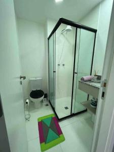 uma casa de banho com uma cabina de duche em vidro e um WC. em Estúdio Brás - Comercial em São Paulo