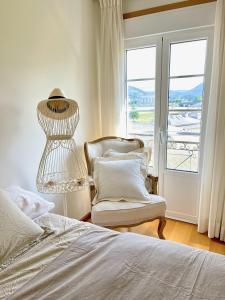1 dormitorio con 1 cama, 1 silla y 1 ventana en The Cliffs - Passion Eccehomo, en Viveiro