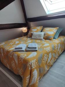 a bed with an orange blanket and pillows on it at La Marisa, studio cosy 10min Disney. in Crecy la Chapelle