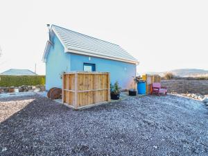 a blue house with a gate and a fence at Mountain View in Kinvara