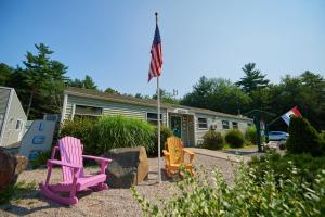 a group of colorful lawn chairs in front of a house at Moody Beach Camping Resort Loft Park Model 14 in Moody