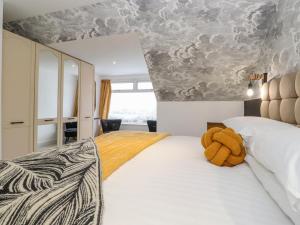 a bedroom with a bed with a teddy bear on it at Pheasants Folly in Windermere