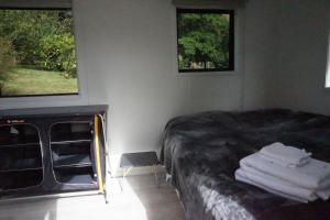 1 dormitorio con 1 cama con toallas en Cable Bay Farm, en Nelson
