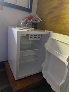 an empty white refrigerator with its door open at Pousada das Brumas in Brumadinho