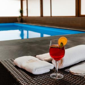 a glass of wine sitting on a table next to a pool at Aries Vârtop in Vartop