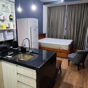 una cocina con fregadero y una cama en una habitación en Loft no Alto en Teresópolis